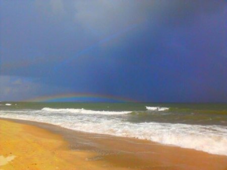 Summer storms put on quite a show when you watch them roll in from the beach. A recent squall crept in from the north and the sun from the beach produced a rainbow beneath the front.